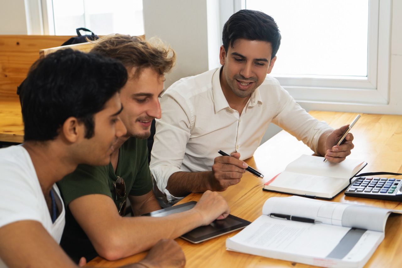 Young Teacher telling two students about corporate budgeting